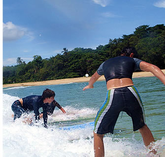 Surflektioner för barn på Wizard stranden i Bocas del Toro, Panama